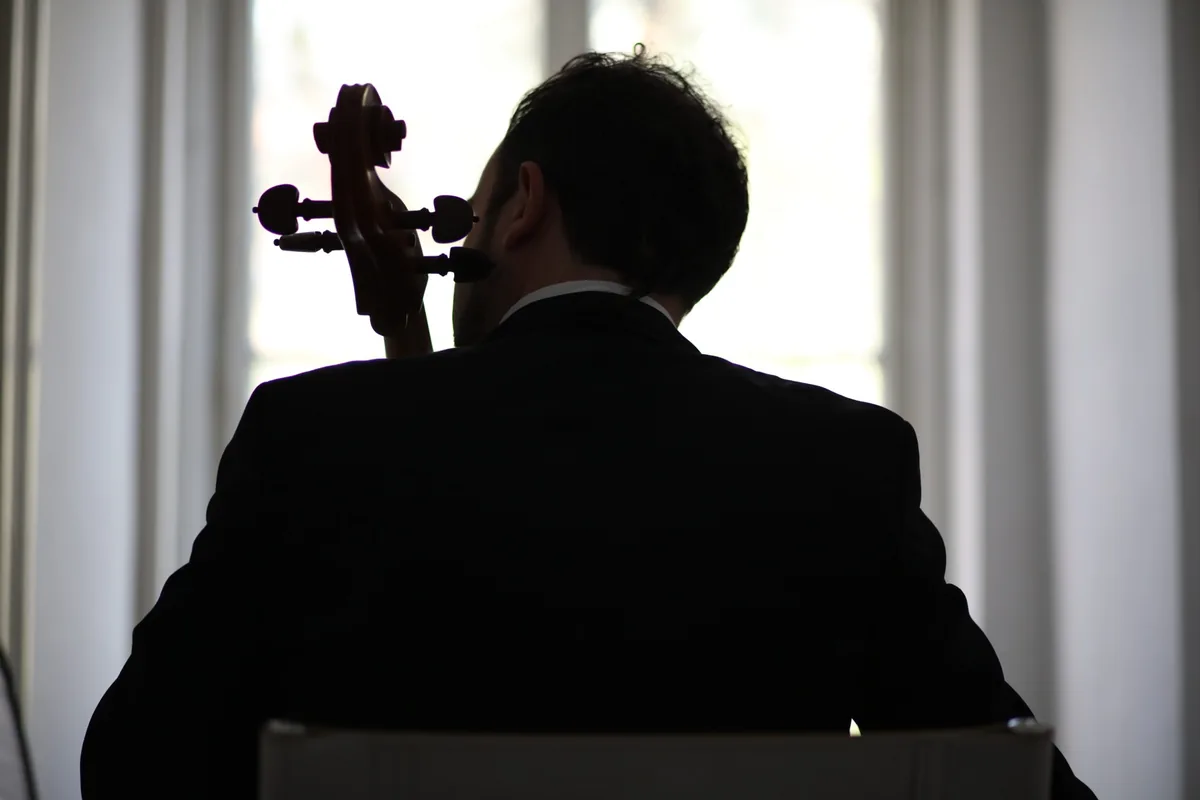Lucio Amanti seen from behind with his cello